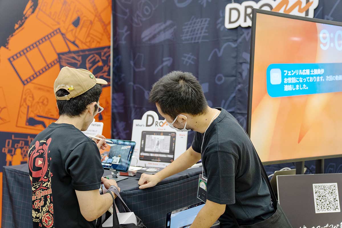 京まふのドローミのブースで絵コンテを体験する来場者と説明するフェンリルのメンバー